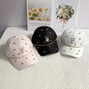 Detail of jacquard baseball caps featuring rhinestone bear motif and pearl heart charm
