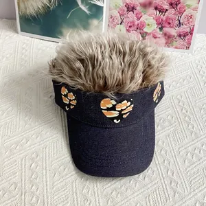 Detailed view of heart-shaped tiger print patches and realistic synthetic hair on denim visor
