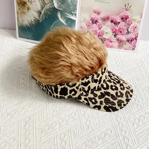 Detalle de gorra de béisbol con estampado de leopardo y creativa peluca de pelo marrón claro