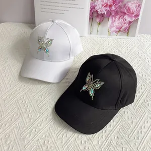 Fashionable baseball caps in black and white with sparkling rhinestone butterfly design