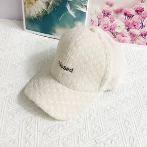 Nahaufnahme der flauschigen Textur und missed Bestickung dieser warmen beige Kappe