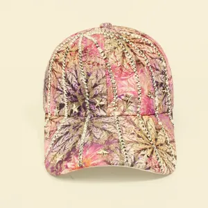 Detail of pink floral lace baseball cap with silver studs and star metallic ornaments