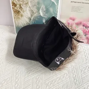 Vista del forro de gorra negra con pelo de peluca marrón y bordado de gato