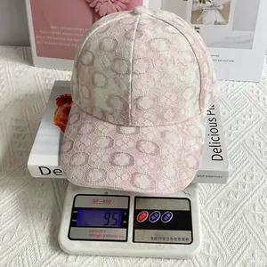 Dettaglio di un cappello da baseball in pizzo rosa e bianco da 95g su una bilancia