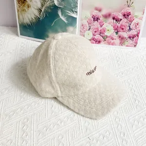 Detailansicht der cremefarbenen Teddy-Fleece-Struktur mit missed-Stickerei auf der Kappe