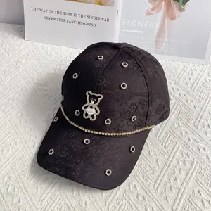 Detail of black jacquard baseball cap with rhinestone bear and heart decoration
