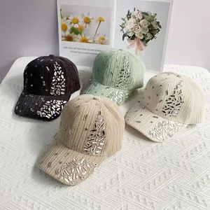 Detail of velvet baseball caps with silver rhinestones in black, green, and beige colors