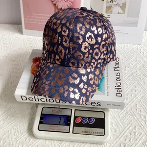 Detail showing the lightweight 77g navy blue denim baseball cap with gold leopard print