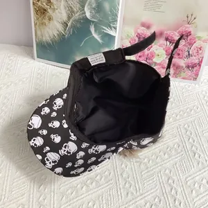 Close-up of 100% cotton label and skull pattern detail on a black baseball cap
