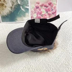 Detail view of denim wig cap showing adjustable velcro strap and 100% cotton inner lining