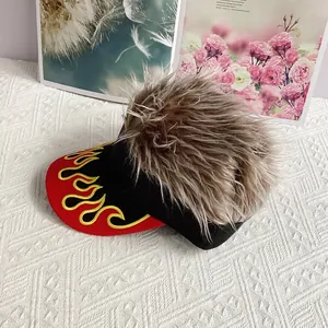 Détail de la broderie de flammes jaunes sur une visière bicolore avec cheveux synthétiques