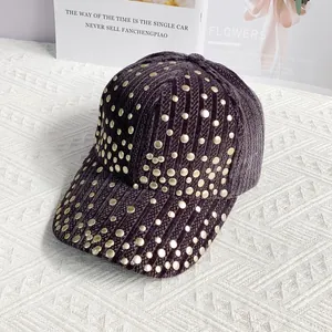Detail view of purple velvet baseball cap with gold rivet studs and textured rib fabric