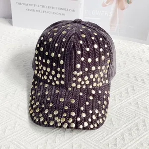 Detail of dark purple corduroy texture and golden metal rivets on a punk style baseball cap