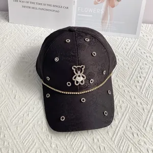 Detail of floral jacquard baseball cap with rhinestone bear and heart pearl accent