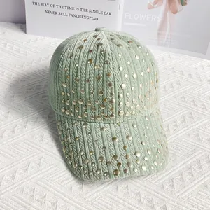 Close-up of light green corduroy baseball cap with golden metal rivet decorations
