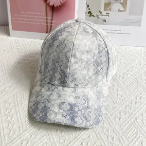 Dettaglio del berretto da baseball in pizzo azzurro e bianco con trama floreale traforata