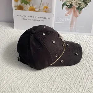 Detail of black jacquard baseball cap featuring rhinestones and pearl flower pattern