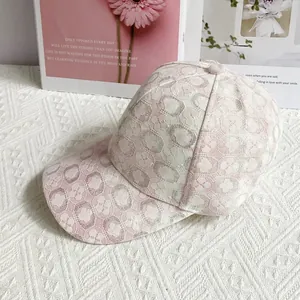 Dettaglio della trama in pizzo floreale rosa su un cappello a rete traspirante