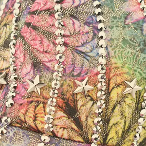 Detailed macro of floral print baseball cap with sparkling rhinestones and metal stars