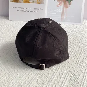 Detailed view of black jacquard baseball cap with rhinestone accents and metal buckle
