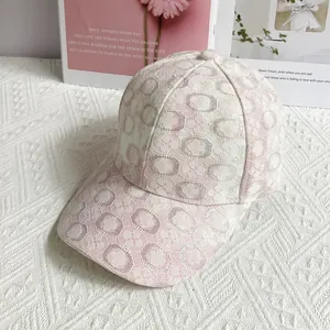 Dettaglio del cappellino da baseball in pizzo rosa e bianco con ricamo floreale
