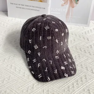Dettaglio del berretto da baseball in velluto grigio scuro con lettere metalliche decorative