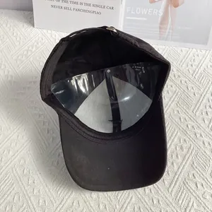 Detail of black jacquard baseball cap showing fabric texture and structured inner support