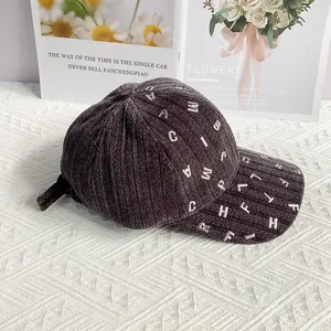 Dettaglio del cappellino da baseball in velluto a coste grigio scuro con lettere metalliche