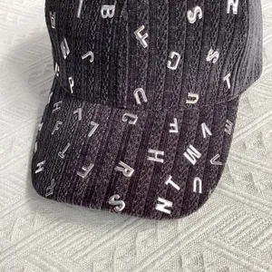 Dettaglio del berretto da baseball in velluto nero con lettere metalliche argentate