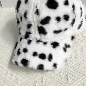 Close-up of soft faux fur baseball cap featuring a black and white cow print texture