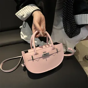 Pink leather half-moon handbag with silver hardware and shoulder strap shown by a model