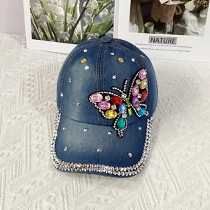 Detail of colorful rhinestone butterfly design on navy denim baseball cap with silver crystals