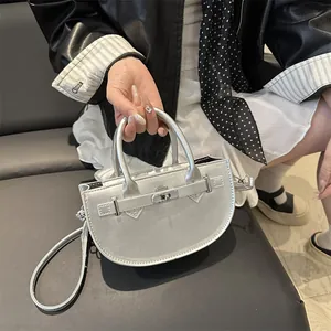 Silver semi-circle chain crossbody bag with metallic finish and buckle closure