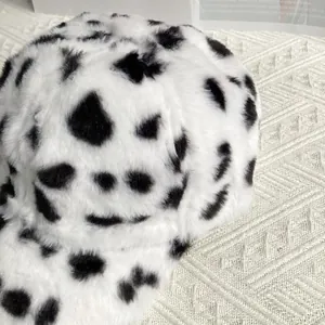 Close-up of plush faux fur baseball cap with cow pattern texture and soft fuzzy material