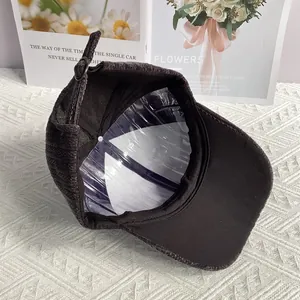 Dettaglio del cappello da baseball in velluto a coste grigio con fibbia in metallo regolabile