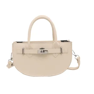 Elegant beige half-moon handbag with silver buckle and curved handle in minimalist style