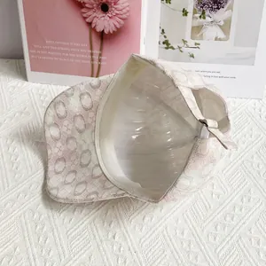 Dettaglio interno del cappellino in pizzo rosa con cinturino regolabile e fibbia in metallo