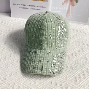 Detailed view of light green corduroy baseball cap adorned with sparkling rhinestones