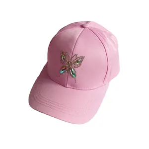 Pink cotton baseball cap featuring a decorative rhinestone butterfly on the front crown