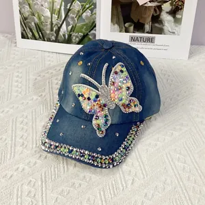 Detailed close-up of rhinestone butterfly on indigo denim baseball cap with glitter brim