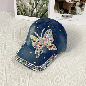Detail of blue denim baseball cap with colorful rhinestone butterfly and crystal brim