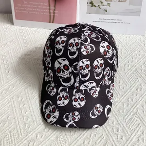 Close-up of black baseball cap with white skull patterns on a white knit background