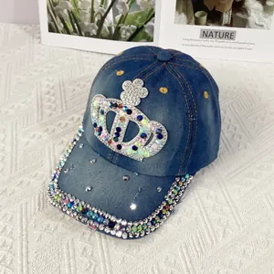 Close-up of a blue denim baseball cap featuring a colorful rhinestone crown and embellished brim