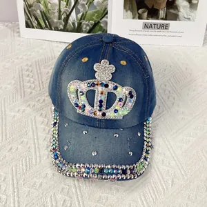 Close-up of crown rhinestone patterns and metal studs on blue denim baseball cap