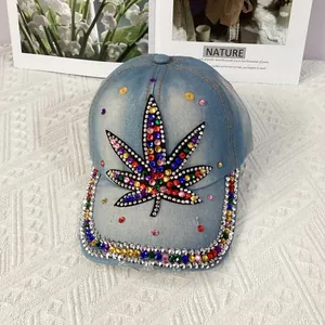 Detail of colorful rhinestones on light blue denim baseball cap with maple leaf design