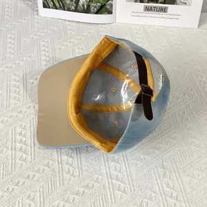 Detail view of denim baseball cap interior with yellow sweatband and adjustable leather strap