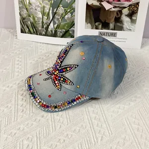 Detail of colorful rhinestones maple leaf design on light blue washed denim baseball cap