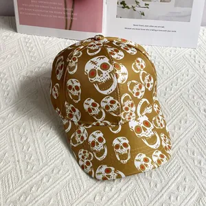 Top view of yellow baseball cap with all-over skull print on artistic magazine background