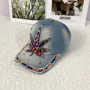 Detailed close-up of colorful rhinestone maple leaf on a light blue denim baseball cap