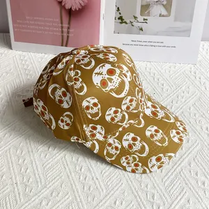 Detail of street-style baseball cap in ginger yellow with skull print on white fabric